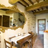 Oval antique mirror amd view of the kitchen area with table and chairs. wedding tuscany villa