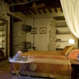 View of one of the bedrooms, flat screen TV, antique bed and wooden furniture. wedding villa tuscany