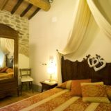 One of the 4 bedrooms, each room has antique terracotta floors and original wooden beams.villa wedding Italy