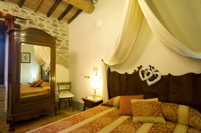 One of the 4 bedrooms, each room has antique terracotta floors and original wooden beams.villa wedding Italy